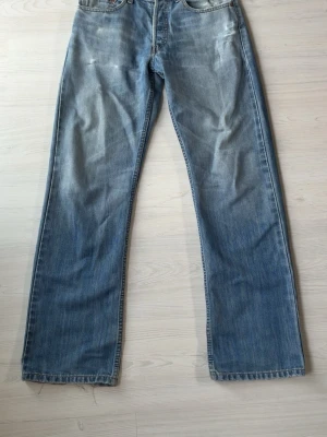 Levi's 510 jeans - Klassiska blå jeans från Levi's med rak passform och fem fickor. Jeansen har en ljus tvätt med slitningar och den ikoniska röda Levi's-lappen på bakfickan. Passar en avslappnad look.