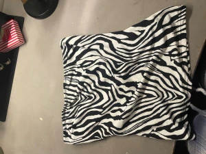 Zebramönstrad tubtopp - Cool zebramönstrad tubtopp i svart och vitt. Perfekt för dig som vill sticka ut och köra på djurmönster. Toppens passform är tight och den är ärmlös, vilket gör den enkel att matcha med olika outfits.