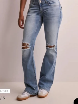 Ljusblå bootcut jeans med slitningar💗 - Säljer ett par ljusblå bootcut jeans med slitningar över knäna. 