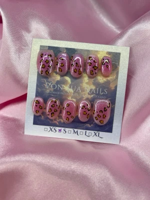 PinkLeo (S);ExtraShortOval  - Handgjorda press-on naglar i glittrigt rosa med trendigt leopardmönster. Naglarna har en extra kort oval form och cool design som sticker ut. Perfekt för dig som vill ha unika och snygga naglar utan att gå till salong.S: 15 mm, 11,5 mm, 12 mm, 11 mm, 9 mm 