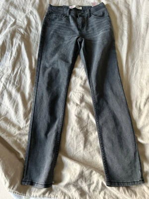 Mörkgrå raka jeans - Snygga mörkgrå jeans med rak passform och klassisk femficksdesign. Jeansen har normal midja och stängs med dragkedja och knapp. Perfekta till en avslappnad stil och funkar året runt.