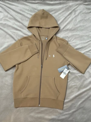 Beige hoodie från Polo Ralph Lauren - Snygg beige hoodie från Polo Ralph Lauren med dragkedja. Den är helt ny med lappar. Köpt på hedefashion outlet. Äkthets bevis finns se bilder.