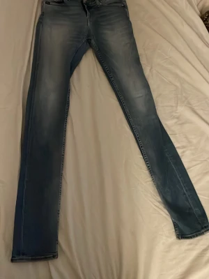 Tiger of sweden jeans - Snygga blå slim fit jeans med lätt slitna detaljer och klassisk femficksmodell. Jeansen har en tvättad look och raka ben. Perfekta till en avslappnad stil och passar till det mesta i garderoben. W27 L30