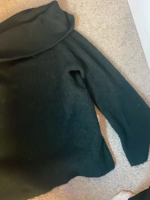 Svart hoodie med stor huva - Mysig mörkgrön skickad tröja. långa ärmar. Tillverkad i ett mjukt material som känns skönt mot huden. Perfekt för dig som gillar en enkel och stilren look. Passar till det mesta och är lätt att matcha med andra plagg.