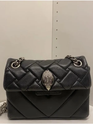 Svart handväska Kurt Geiger - Kurt Geiger handväska i den lilla modellen med silver kedja. Använd men fortfarande fint skick, förutom lite slitningar som finns på sista bilden