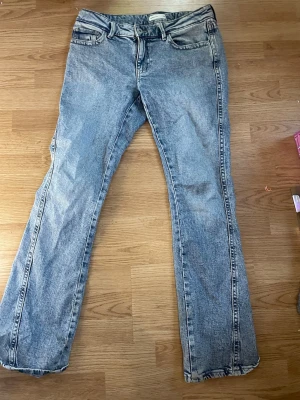 Gina ljusblå bootcut - , Säljer ett par ljusblå bootcut jeans med snygga detaljerade sömmar på bakfickorna. Jeansen har klassisk femficksdesign och är tillverkade i jeansmaterial med en skön passform. Perfekt för dig som gillar retrovibbar och stilrena jeans. Köpt för 250kr
