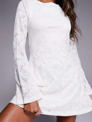 Vit spetsklänning med öppen rygg - Kort krämvit studentklänning i spets med långa ärmar och en snygg öppen rygg som knyts i nacken. Klänningen har ett blommigt mönster i spetsen och lätt utsvängda ärmar för en trendig look. Perfekt för dig som vill sticka ut med en elegant och modern stil. Klänningen är köpt på Asos men är från Princess Polly, det står på lappen