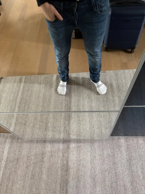 Blå slim fit/glenn jeans med stretch från Jack Jones - Säljer ett par blå slim fit jeans med snygg tvätt och lätt slitna detaljer. Jeansen har klassisk femficksmodell, normalhög midja och smal passform hela vägen ner. Sköna tack vare stretchigt material. Perfekta till en avslappnad stil.