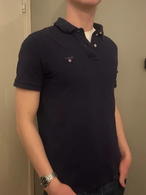 Gant Piké - M - Säljer denna snygga marinblå Gant piké i storlek M. Tidlös och stilren modell som passar till det mesta. I bra använt skick.  Om du har några frågor tveka inte att höra av dig. Allt gott Deluxe Garderoben.