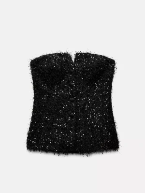 Svart paljettprydd korsettopp - Snygg svart korsettopp med paljetter och fluffig textur. Toppen är axelbandslös och har knappar framtill för en extra cool look. Perfekt för dig som vill sticka ut med en unik och trendig topp. ( EN KNAPP ÄR SÖNDER, MEN GÅR ATT FIXA) 
