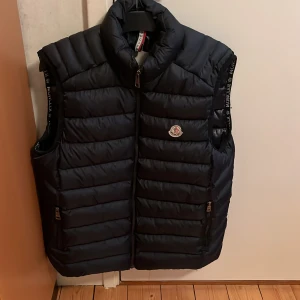 Svart dunväst Moncler - Säljer en snygg dunväst från Moncler, använd ett fåtal gånger. Säljer för att den är för stor för mig. Passar perfekt nu till våren!