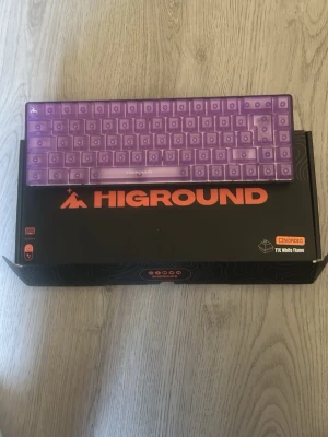 Lila Higround tangentbord Amethyst - Säljer ett Higround Amethyst tangentbord med nordisk layout och TTC White Flame-switchar. Tangentbordet är lila och har ett genomskinligt plastchassi och keycaps. Kommer i originalkartong och har en kompakt formfaktor som passar perfekt till gaming eller skrivbordet.