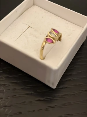 Äkta guldring 14k med rubinstenar - Snygg guldring med tre droppformade stenar i rosa och vitt. Storlek mellan 14-15. Aldrig använd. Väldigt vacker!