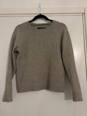 Beige stickad tröja från Vero Moda - Mysig beige stickad tröja från Vero Moda med rund halsringning och långa ärmar. Tröjan har ribbstickade muddar vid ärmslut och nederkant. Perfekt för lager på lager och enkel att matcha med olika outfits.