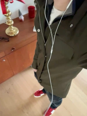 Mörkgrön Field jacka  - Stilren mörkgrön vindjacka från med fyra stora fickor framtill och hög krage. Jackan har rak passform och är tillverkad i ett slitstarkt, vindtätt material som passar perfekt för blåsiga dagar. Custom kors på ryggen 