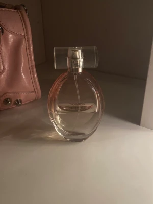 Calvin Klein Sheer Beauty parfym 50ml - Säljer en Calvin Klein Eternity parfym i en elegant, rund glasflaska med transparent lock. Doften är klassisk och flaskan har en stilren design med subtil rosa ton i vätskan. Perfekt för dig som gillar tidlösa parfymer. Halva använd💗