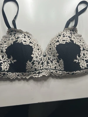 Svart spets-bh med vita detaljer - Svart blom bh ser nästan ut som intimissimis pretty flowers bh men vet ej vart den är ifrån! 