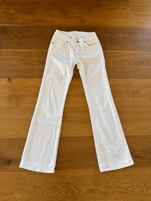 Vita low waisted bootcut jeans från Subdued  - Snygga vita bootcut jeans från Sublevel med klassisk femficksmodell och silverfärgade detaljer. Jeansen har normal midja och är tillverkade i ett mjukt bomullsmaterial med lite stretch för extra komfort. Passar som 36