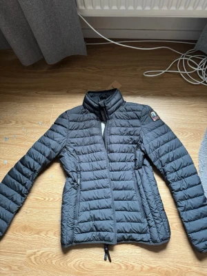 Parajumpers jacka - Säljer en Parajumpers lättviktsjacka i storlek Large. Jackan är oanvänd och i väldigt fint skick.  Info: 	•	Märke: Parajumpers 	•	Storlek: L 	•	Färg: Svart 	•	Skick: Oanvänd / mycket bra skick 	•	Modell: Lättviktsjacka / dunliknande jacka 	•	Detaljer: Klassisk Parajumpers-logga på armen, dragkedjefickor och innerficka.        