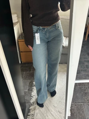 Ljusblåa raka jeans från Gina Tricot - Säljer ett par ljusblåa jeans från Gina Tricot med en midja man viker över. Ny med prislapp. 