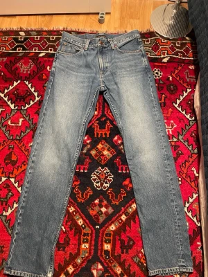 Nudie Gritty Jackson 32/34 - Ljusblå jeans från Nudie Jeans. Modellen är Gritty Jackson. Storlek 32/34. Fint skick och utan skador eller hål. Nypris 1 600 kr.