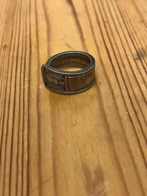 Ring gjord av sked - Unik silverfärgad ring gjord av en antik sked med detaljerade, graverade mönster på sidorna. Storlek S/M, kan återkomma med mått!