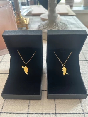 Arrow heart necklace  -  Två matchande guld halsband med delade hjärthängen – perfekta att dela med en vän eller partner. Halsbanden är 100 % rost- och nickelfria. Kedjorna är 40 cm långa men kan förlängas med ytterligare 5 cm. Hör gärna av dig om du har några frågor ☺️