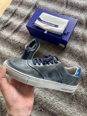 HELT NYA Jacob Cohen skor - Hej! Säljer nu dessa väldigt snygga och eftertraktade Jacob Cohen skor, de är utsålda överallt. Skorna är perfekt nu till våren och sommaren. Storlek 40 Skick: 10/10, helt nya, box och dustbag ingår. Nypris: 5999kr Säljs för: 2499 kr