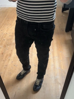 Svarta slim fit jeans - Säljer ett par svarta slim fit jeans med klassisk femficksdesign och normal midja. Jeansen har en stilren look och passar perfekt till en avslappnad streetstil. Materialet känns mjukt och följsamt, vilket gör dem sköna att bära hela dagen.