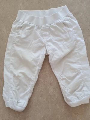 Byxor - Snygga vita byxor med bred, elastisk midjemudd och avslappnad passform. Byxorna har fickor på sidorna och är tillverkade i mjuk bomull, perfekta för varma dagar. Stilen är enkel och clean, passar dig som gillar en chill vibe. Finns fläckar.