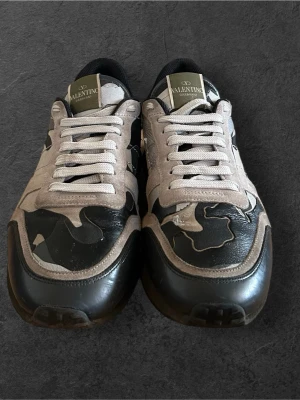 Rockrunner - Säljer ett par snygga sneakers från Diadora i svart och vitt. Skorna har en klassisk låg modell med snörning och detaljer i både mocka och läder. Perfekta för dig som gillar sportig stil och vill ha något som sticker ut lite extra.