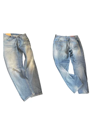 Blå dondup jeans  - Säljer ett par ljusblå jeans från dondup Jeans med rak lite loose passform och klassisk femficksdesign. Jeansen har slitningar och tvättade detaljer för en avslappnad look. Knappgylf och läderpatch bak i midjan. Modell brighton.