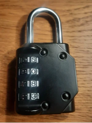 Svart kombinationslås i metall - Säljer ett svart kombinationslås med tre kodhjul i silverfärg. Låset är tillverkat i metall och har en robust design med rundad bygel. Perfekt för att låsa skåp, väskor eller gymfack.