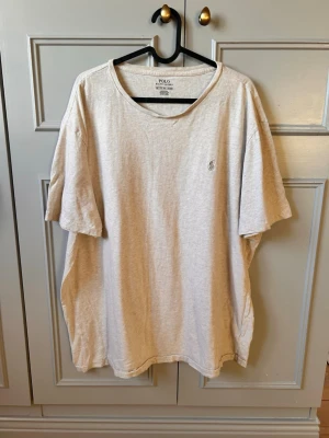 Beige t-shirt från Polo Ralph Lauren - Säljer en beige t-shirt från Polo Ralph Lauren i storlek XXL. T-shirten har klassisk passform, rund halsringning och korta ärmar. Diskret broderad logga på bröstet. Tillverkad i mjuk bomull för en skön känsla. Den här är helt nya aldrig haft på