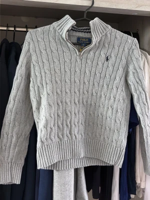 Grå halfzip tröja polo Ralph lauren - Säljer denna halfzip ifrån polo Ralph lauren i storlek 8 år. Skulle säga att det motsvarar runt 130-140.  Tröjan är i fint skick och är såklart äkta köpt ifrån kids brand store. Hör av er för flera frågor och funderingar:)