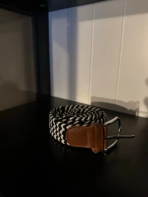 Flätat svart vitt bälte - Ett riktigt snyggt flätat bälte. Bältet är svart vitt och passar till det mesta. Skicket är otroligt bra då de endast är använt någon enstaka gång. Skriv vid frågor och kolla gärna in min profil för fler bälten och kläder!