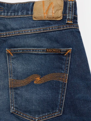 Blå jeans från Nudie Jeans - Säljer ett par klassiska blå jeans från Nudie Jeans med raka ben och snygga kontrastsömmar. Jeansen har två bakfickor med den ikoniska vågstickningen och en läderpatch i midjan. Tillverkade i slitstark denim av bomull.