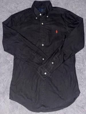 Ralph Lauren skjorta - Svart Ralph Lauren skjorta i storlek S. Väldigt fint skick. Använd 1 gång. Inga knappar saknas. Hör av dig vid frågor! 