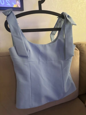 Blåa topp med rosetter Zara - Supersöt ljusblå linnetopp med breda axelband som knyts i stora rosetter på axlarna. Från Zara i storlek M. Typ helt oanvänd! Skriv för fler bilder eller frågor💖