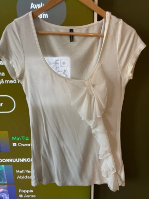 Vit topp med volangdetalj  - Snygg vit topp från amisu med volanger framtill 