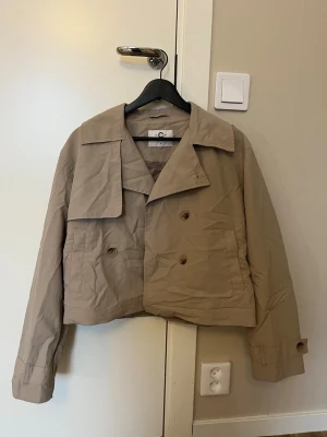 Beige trenc coat  - Utsåld beige trenchcoat från Cubus barn. Använd fåtal gånger så som ny. Nytvättad därav skrynklig. Nypris 399kr. Storlek 164, sitter som XS. Säljer då jag har en till. Tryck gärna på köp nu. 