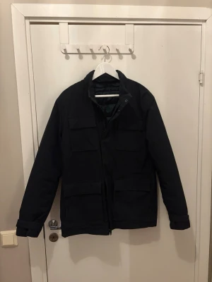 Svart parkas från John Henric - Snygg svart fieldjacket från John Henric.  Använd MAX 3-4 gånger och skick 9/10 , nypris 2500 kr mitt pris 750 kr, skriv vid minsta fundering!!!