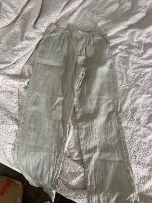 Beiga linnebyxor från Jack & Jones - Säljer ett par beiga linnebyxor från Jack & Jones med avslappnad passform och resår i midjan. Byxorna har raka ben och är tillverkade i ett lätt och luftigt linnematerial.