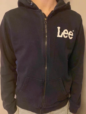 Mörkblå hoodie med dragkedja från Lee - Snygg Lee zip up tröja/ hoodie i färgen mörkblå. Köpt för 200kr säljer för att jag behöver pengar och vill bli av med gamla kläder.