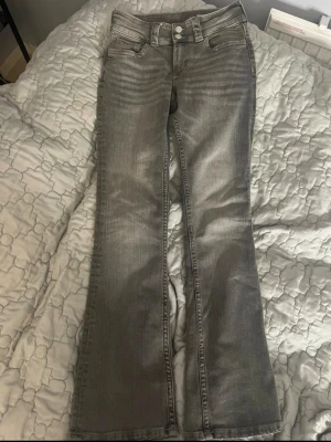 Grå bootcut-jeans – låg midja – stretch – Y2K-stil - Snygga grå jeans i bootcut-modell med låg midja. Stretchigt material som sitter bekvämt och snyggt. Fint tvättad grå färg med lätt slitning för en trendig Y2K-look.  ✨ Nytt skick(nya utan prislapp) inga hål eller fläckar ✨ Modell: Bootcut / flare ✨ Midja: Låg ✨ Färg: Grå ✨ Material: Stretch  ✨storlek 158 passar mig som har xs justerbar midja   #bootcut #flarejeans #y2k #gråjeans #lowrise #vintage #trend #90tal #2000tal