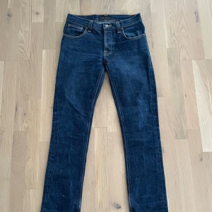 Blåa nudie jeans grim tim - Säljer ett par riktigt schysta nudie jeans i modellen grim Tim. Passformen sitter som slim/ straight. Skicket är perfekt och jag inga defekter eller liknande 