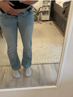 Ljusblå bootcut jeans - Säljer ett par ljusblå bootcut jeans med normal midja. Jeansen har raka ben och är tillverkade i mjukt jeanstyg. OBS storlek xxxs (152)
