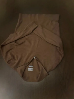 Brun merinoullströja med half zip - Snygg brun tröja från Arket i mjuk merinoull. Modellen har en stilren half zip-dragkedja vid kragen och långa ärmar. Perfekt för dig som gillar en enkel men trendig look.