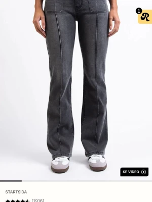 madlady Bootcut svarta jeans med fickor  - Snygga bootcut jeans i mörkgrått med markerade sömmar och stora fyrkantiga fickor framtill. Jeansen har klassisk knapp fickor. Storlek TALL EU36, använd 1 gång. 