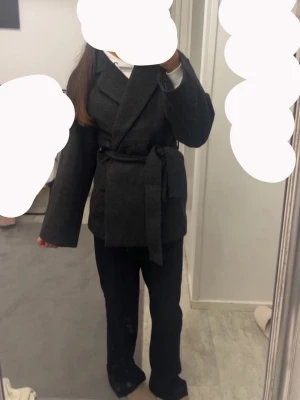 Mörkgrå kappa med knytskärp - säljer en mörkgrå kappa med bred krage och knytskärp i midjan. Kappan har en rak passform och långa ärmar, perfekt för våren och hösten dagar. Tillverkad i ett mjukt tyg som ger en snygg och avslappnad look. Kappan är från lager 157 och är i storlek XS men passar även S. skriv om ni har frågor eller vill ha mer bilder 🤗🤗